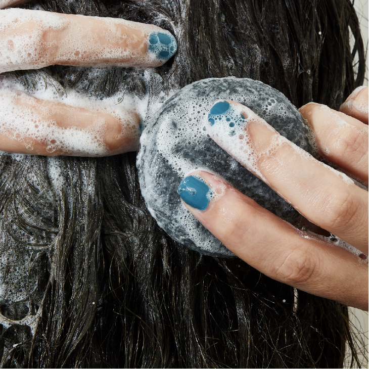 Woman washing hair with soap bar