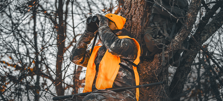 Lifestyle image of hunter in a tree